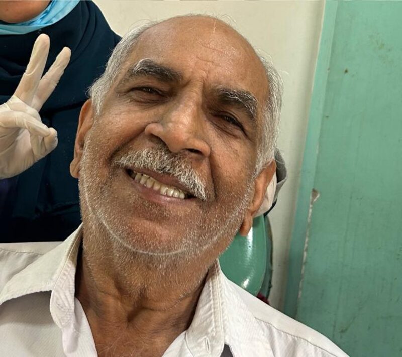 The same patient smiling after complete denture treatment at Niyaz Dental Unit
